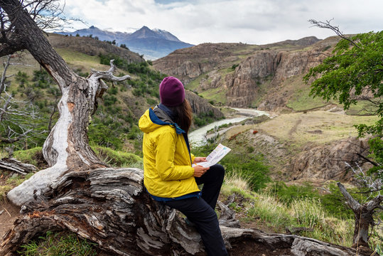 A Hiker Woman Looks A Map On A Trekking Day In El Chalten, Patagonia, Argentina