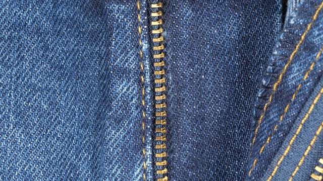 Opened fly on a pair of jeans, tracking. Close up top view. Slider shot. 4K 422 10 bit