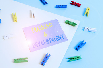 Conceptual hand writing showing Training And Development. Concept meaning learn specific knowledge to improve perforanalysisce Colored clothespin paper reminder with yellowblue background