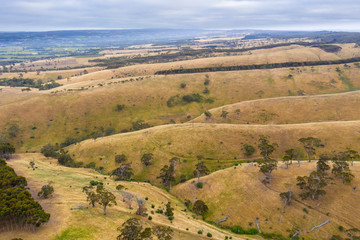 Rolling green hills and trees in farmland south of Adelaide in Australia