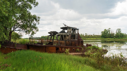 Fototapeta premium Abandoned ships in the river near of Chernobyl. The abandoned river port in Pripyat. Modern ruins. Radioactive metal.