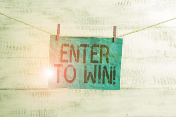 Text sign showing Enter To Win. Business photo text exchanging something value for prize chance winning prize Clothesline clothespin rectangle shaped paper reminder white wood desk