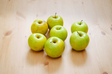 group of green apples on a wooden table