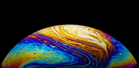 Close up picture of half soap bubble psychedelic color on black background