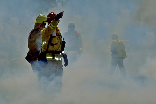 Fire captain engulfed in smoke directs operations in grassland fire, Northern California.  Less rain because of climate change put urban centers adjacent to grasslands in jeopardy
