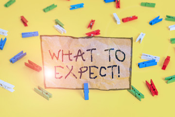 Handwriting text writing What To Expect. Conceptual photo asking about regard something as likely to happen occur Colored clothespin papers empty reminder yellow floor background office