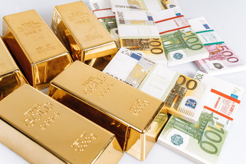 Gold bullions at euro banknotes closeup background. Gold bars lie on Euro banknotes