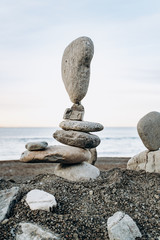 Figures of stones on the beach near the sea. Sea background and stone figures.