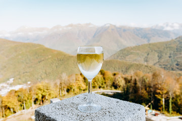 Glass of white wine on the background of beautiful mountains