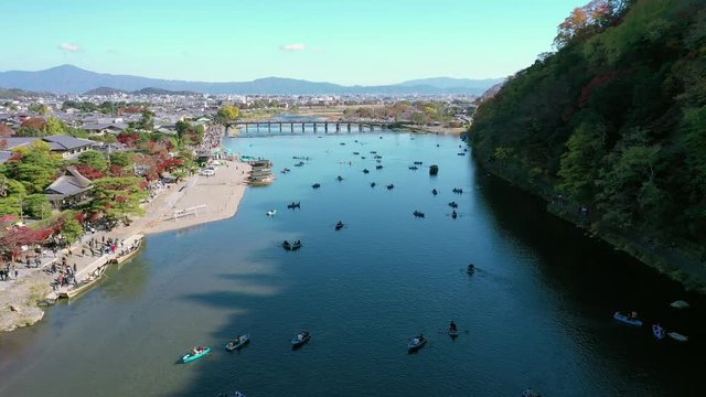 Aerial view 4k by drone of Katsura river at autumn and boats. Arashiyama, Kyoto, Japan