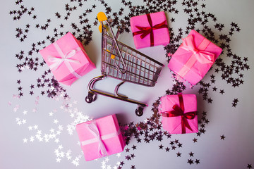 Gift shopping, shopping cart is full of gift boxes. New year's shopping concept