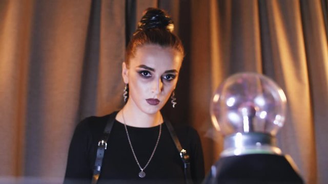 girl removes her hand from the magic electra ball and looks at the camera