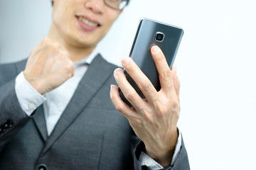 A young business man, he looks at the smartphone screen Happy looking face