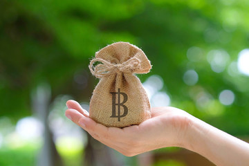 Hand of a woman carrying a purse money .concept saving money and investment concept