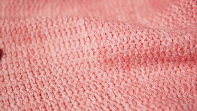 Knitting cloth in soft pink coral color. Woman's hand touches handmade fashionable merino fabric. Checking of fabric quality. UltraHD 4k prores.