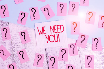 Word writing text We Need You. Business photo showcasing asking someone to work together for certain job or target Scribbled and crumbling papers with thick cardboard above wooden table