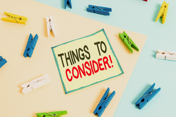 Conceptual hand writing showing Things To Consider. Concept meaning think about something carefully in order to make decision Colored clothespin paper reminder with yellowblue background