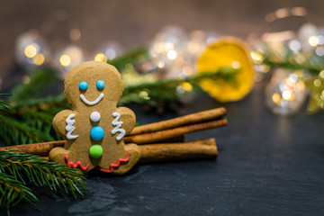 Holiday Christmas gingerbread cookie on slate with dried oranges, anise stars, cinnamon sticks