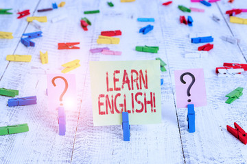Writing note showing Learn English. Business concept for gain acquire knowledge in new language by study Crumbling sheet with paper clips placed on the wooden table