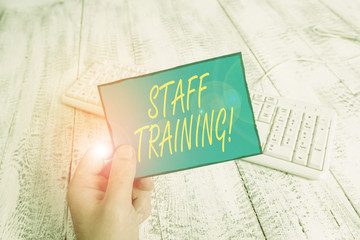 Writing note showing Staff Training. Business concept for learn specific knowledge improve perforanalysisce in current roles Man holding colorful reminder square shaped paper wood floor