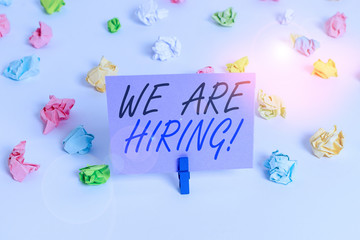 Handwriting text writing We Are Hiring. Conceptual photo recently you employ someone or pay someone to do particular job Colored crumpled papers empty reminder white floor background clothespin
