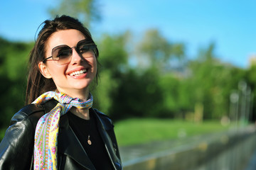 Portrait of a smiling young woman in sunglasses. Girl on the street
