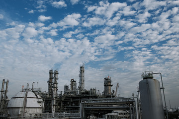 Fototapeta na wymiar Gas distillation tower and gas storage tanks of Petroleum industrial on blue sky with white cloud background, Manufacturing of petrochemical industrial plant