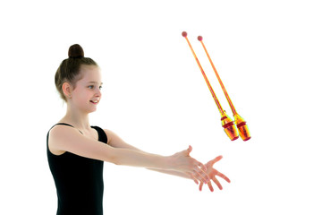 A girl gymnast performs exercises with a mace.