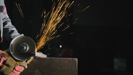 Forge workshop. Smithy manual production. Close up details of sparks, industrial worker using angle...