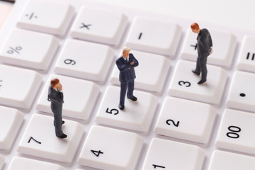電卓の上のビジネスマンの人形