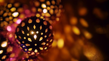 Magic lanterns spin and give beautiful glare to the walls. New Year glowing balls with led diodes are held in hands. Warm lamp light gives cosiness and christmas mood.