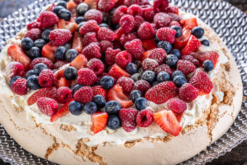 A traditional Australian desert, Pavlova featuring meringue whipped cream, strawberries, blueberries, raspberries