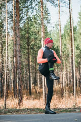 Training an athlete on the roller skaters. Biathlon ride on the roller skis with ski poles, in the helmet. Autumn workout. Roller sport. Adult man riding on skates. The athlete does the workout.