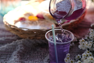 glass of drinks and flowers on wooden table