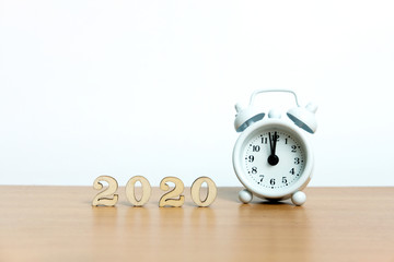 Miniature photography - concept for happy new year 2020 with clock and wooden number block