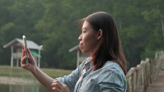 Asian woman take a photo with her smartphone.