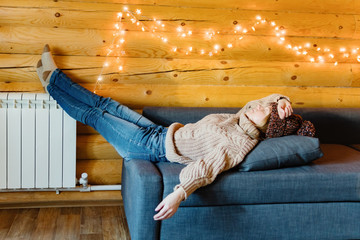 Sleeping in warm house on cozy sofa in log cabin in cold winter.