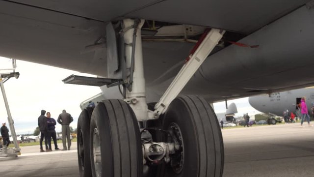 Closeup Of Aircraft Landing Gear With People Walking In Background Slightly Blurred At Airshow