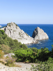 Fototapeta na wymiar Sunny seascape with white rocks, evergreen trees and blue sky. Crimea.