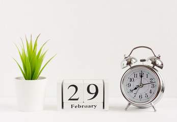 February 29 on a wooden calendar next to the alarm clock.Calendar date, holiday event or...