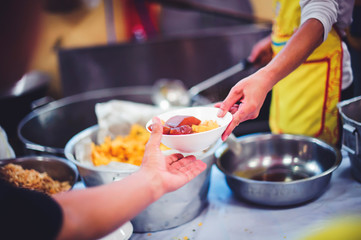 Hungry people are assisted with free charity food from volunteers.