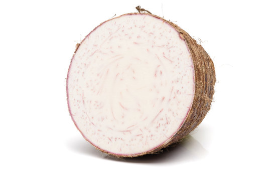 Taro root cut in half placed on a white background.