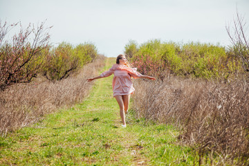 blonde girl in pink dress runs along road