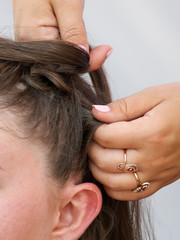 Braiding braids on the head of a girl in the salon