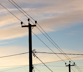 Electric pole with wires on a sunset background