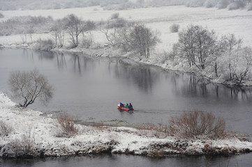Motor boat fishing. River. Winter landscape with the first snow