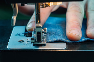 Closeup Male Hand Sewing Denim On A Sewing Machine. Worker Clothes. Macro Shooting. Sewing Still Life.