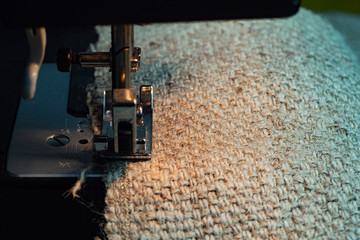 A Sewing Machine Sews Burlap Fabric. Sewing Hemp Fabric Clothing. Close-Up Macro Shot. Sewing Still Life.