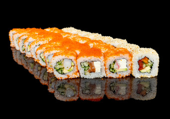 sushi and rolls with different fillings on a black background with reflection