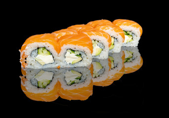 sushi and rolls with different fillings on a black background with reflection